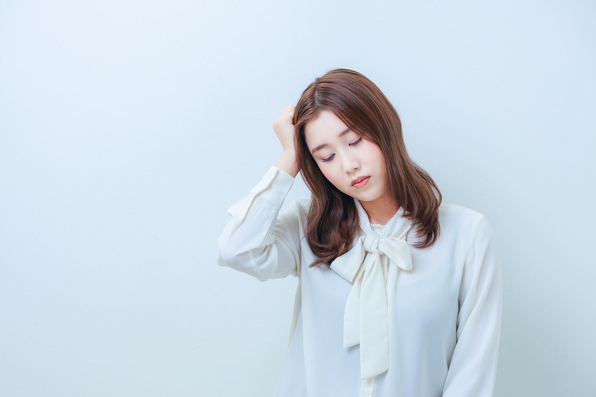 片頭痛で頭を抑える女性